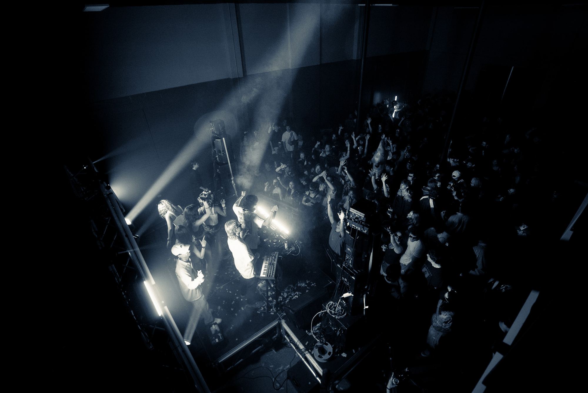Blue beams through haze above a crowd